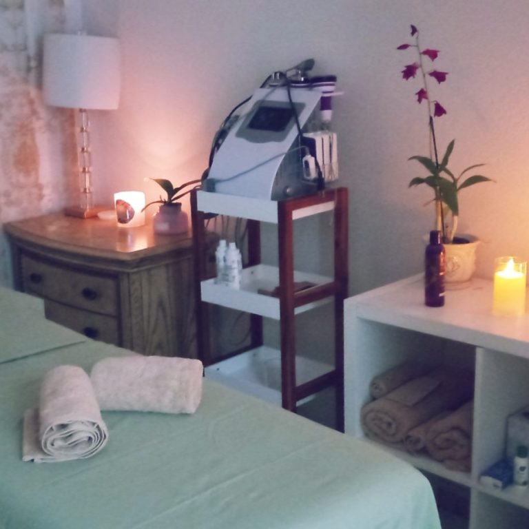 Peaceful spa setting with soft lighting, candles, and towels, designed to promote relaxation