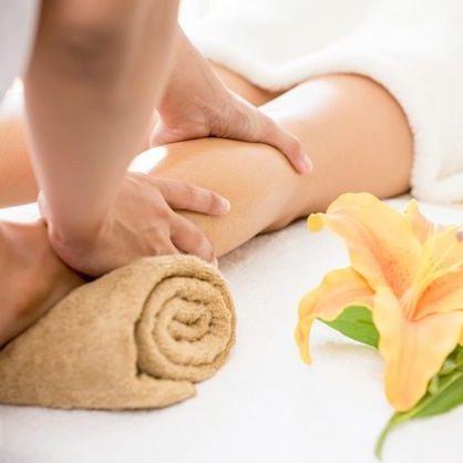Certified massage therapist providing a relaxing arm massage with a flower in the background